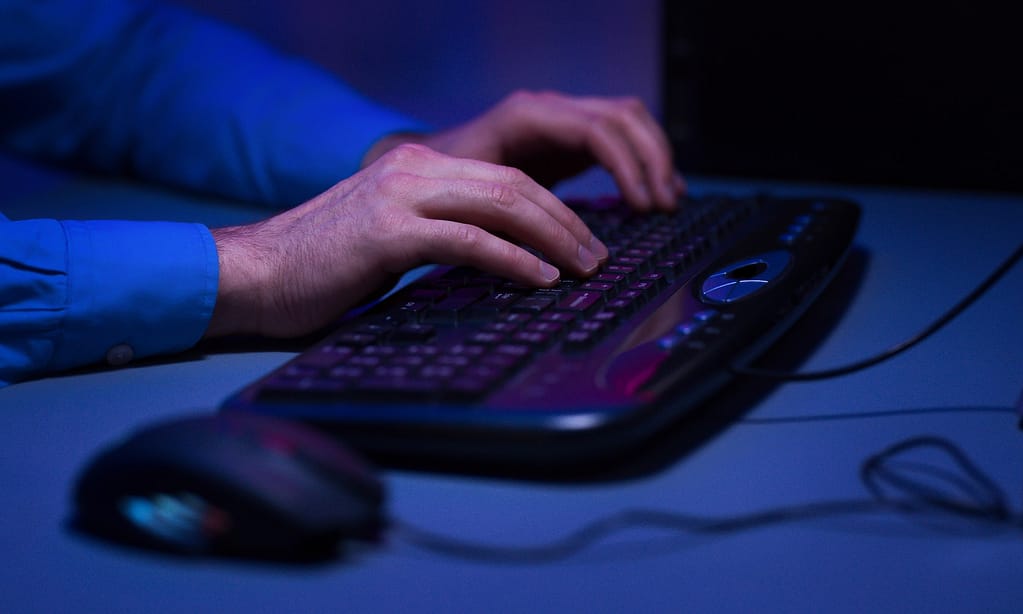 Gamer actively pushing buttons on keyboard, playing games